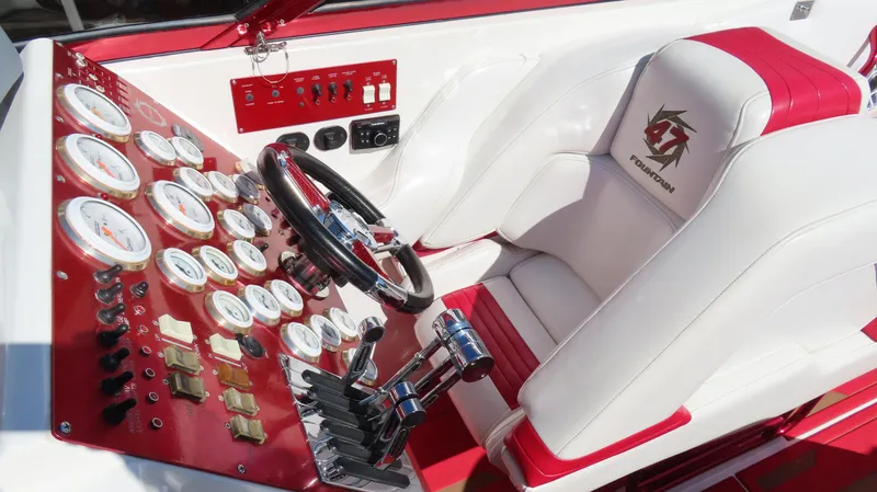 Slide: The Image of Cockpit of 2002 Fountain 47 Lightning boat with red and white dashboard and controls. - 12