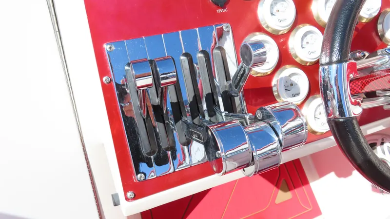 Slide: The Image of Control panel of a 2002 Fountain 47 Lightning boat with chrome levers and gauges. - 13