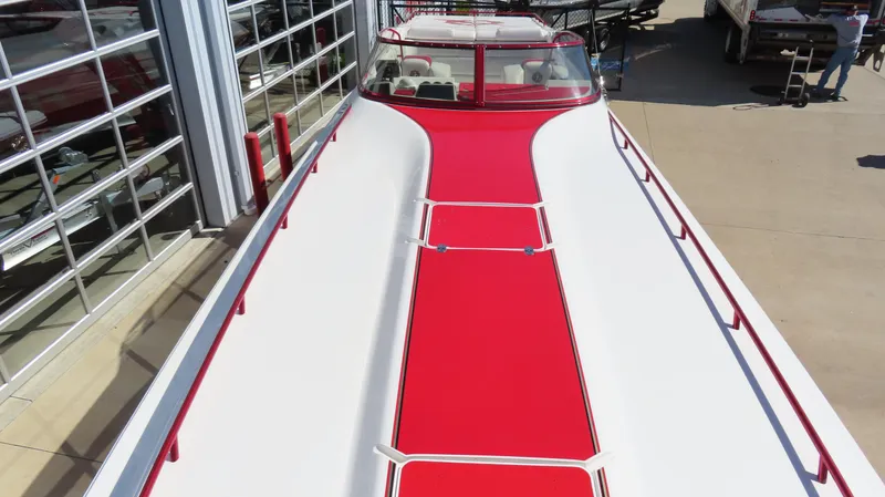 Slide: The Image of 2002 Fountain 47 Lightning boat with red and white design, docked near a building. - 30