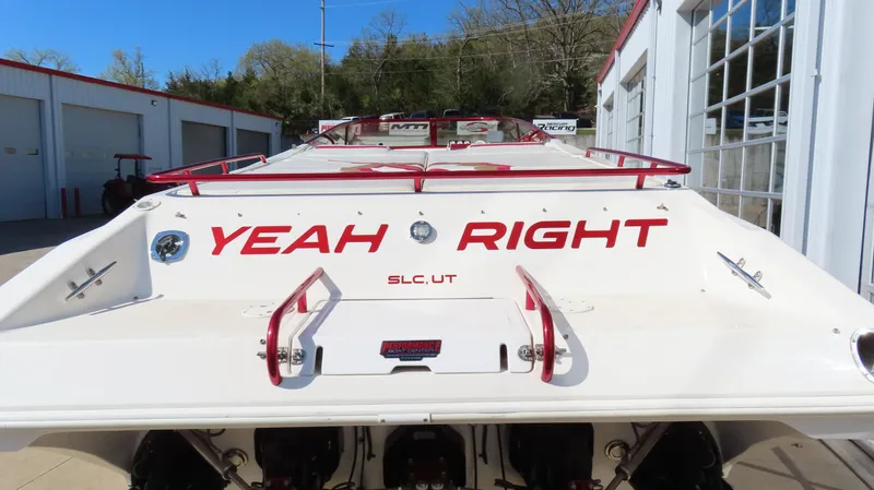 Slide: The Image of 2002 Fountain 47 Lightning boat with "Yeah Right" text on the stern, parked outdoors. - 40