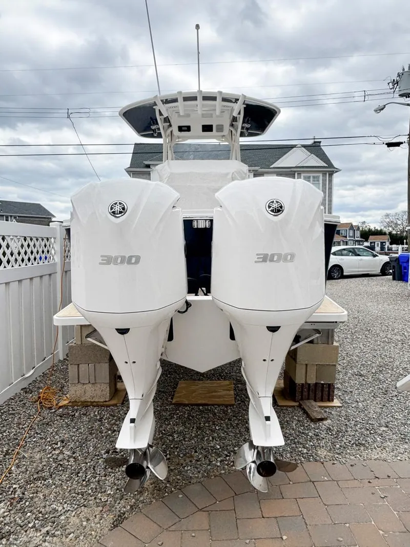 Slide: The Image of 2018 Regulator 28 boat with twin 300 horsepower engines, parked on gravel. - 11