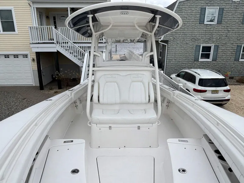 Slide: The Image of 2018 Regulator 28 boat with seating, docked near residential homes. - 16