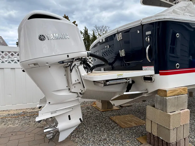 Slide: The Image of 2018 Regulator 28 boat with Yamaha outboard engine, displayed on blocks in a yard. - 19