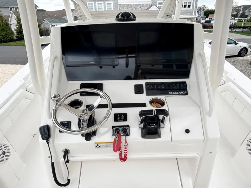 Slide: The Image of 2018 Regulator 28 boat dashboard with steering wheel, controls, and dual screens. - 5