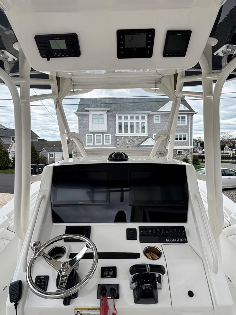Slide: The Image of 2018 Regulator 28 boat dashboard with steering wheel and electronic controls. - 6