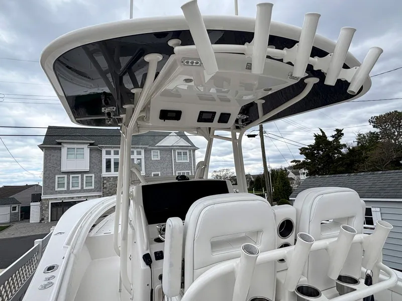Slide: The Image of 2018 Regulator 28 boat with T-top and rod holders, docked near residential area. - 8