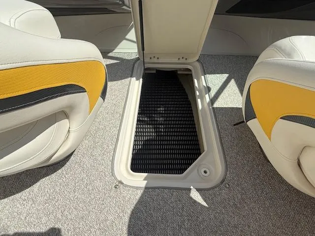 Slide: The Image of 2008 Monterey 194FS boat interior with open storage compartment and yellow-accented seats. - 17