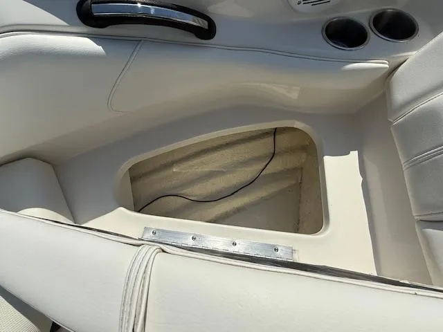 Slide: The Image of Interior of a 2008 Monterey 194FS boat showing storage compartment and cup holders. - 19