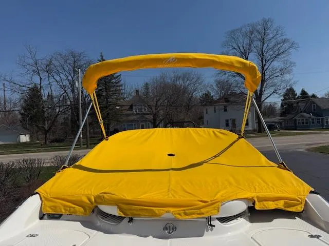 Slide: The Image of 2008 Monterey 194FS boat with bright yellow canopy and cover, parked outdoors. - 40