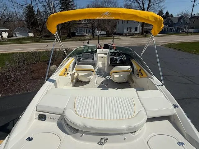 Slide: The Image of 2008 Monterey 194FS boat with yellow canopy and white seating, parked on driveway. - 5