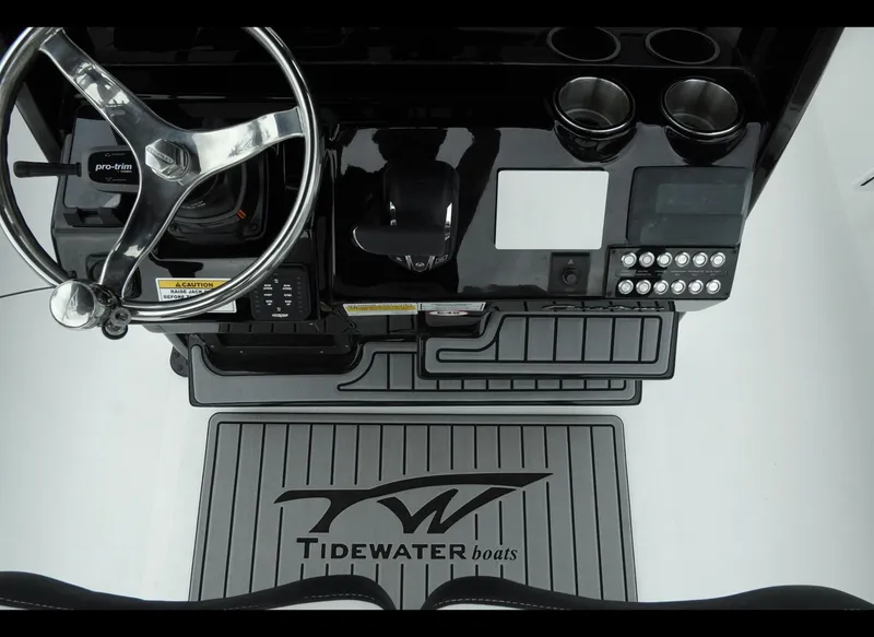 Slide: The Image of 2025 Tidewater 2500 Carolina Bay boat dashboard with steering wheel and control panel. - 14