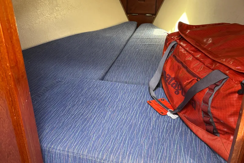 Slide: The Image of Interior cabin of 1985 Catalina 30 sailboat with blue cushions and red duffel bag. - 11