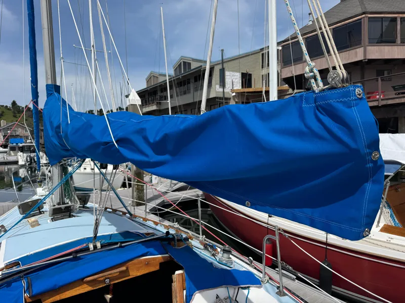 Slide: The Image of 1985 Catalina 30 sailboat with blue sail cover docked at marina. - 17