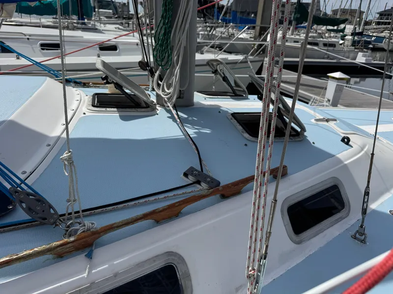 Slide: The Image of 1985 Catalina 30 sailboat deck with open hatches and rigging in a marina. - 20