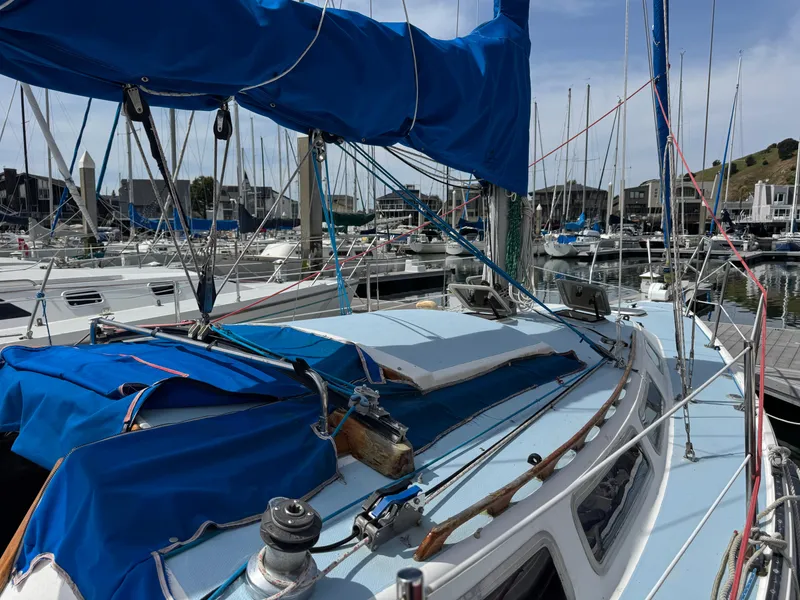 Slide: The Image of 1985 Catalina 30 sailboat docked at marina with blue sail cover. - 21