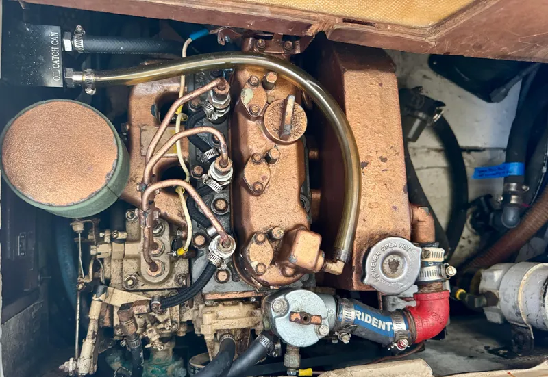 Slide: The Image of Engine compartment of a 1985 Catalina 30 sailboat, showcasing mechanical components and hoses. - 25