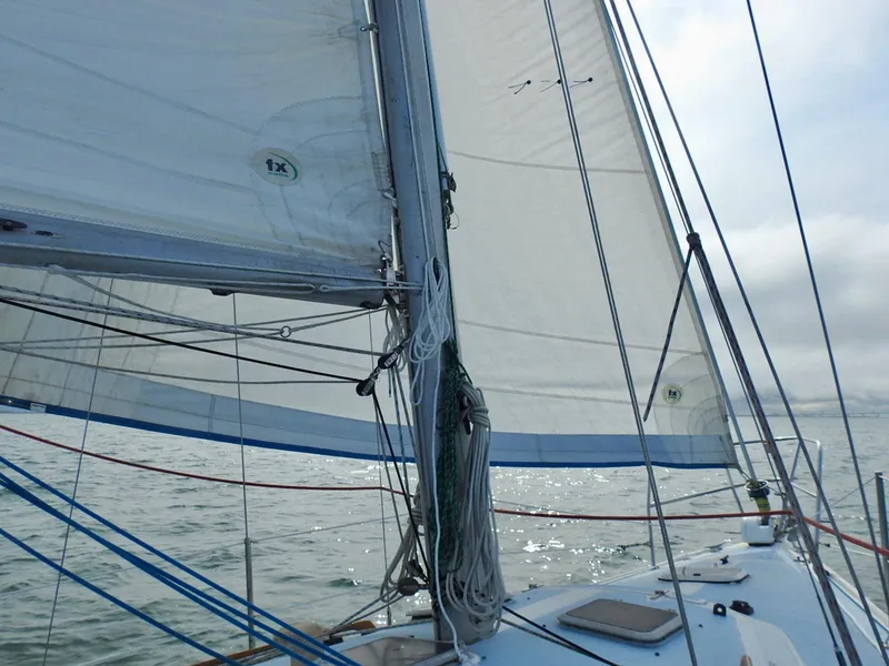 Slide: The Image of 1985 Catalina 30 sailboat on water, showcasing sails and rigging. - 28