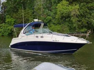 The Image of 2005 Sea Ray 320 Sundancer cruising on a serene, tree-lined waterway. - 0