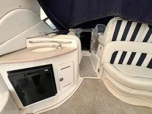 Slide: The Image of Interior of 2005 Sea Ray 320 Sundancer with seating, sink, and mini fridge. - 12