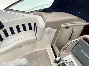 Slide: The Image of 2005 Sea Ray 320 Sundancer cockpit with striped seating and control panel. - 14