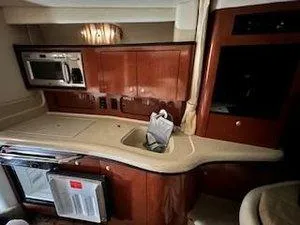 Slide: The Image of Interior of 2005 Sea Ray 320 Sundancer yacht kitchen with wood cabinetry and appliances. - 25