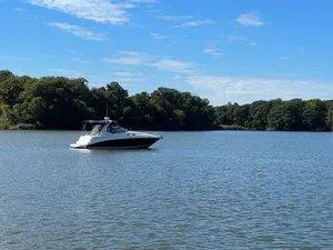 Slide: The Image of 2005 Sea Ray 320 Sundancer boat on a calm lake with a forested shoreline. - 3