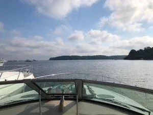 Slide: The Image of 2005 Sea Ray 320 Sundancer cruising on a calm lake under a partly cloudy sky. - 8