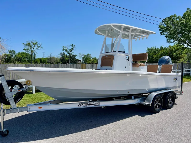 Slide: The Image of 2025 Sea Hunt BX22BR boat on trailer, parked outdoors, under clear blue sky. - 1