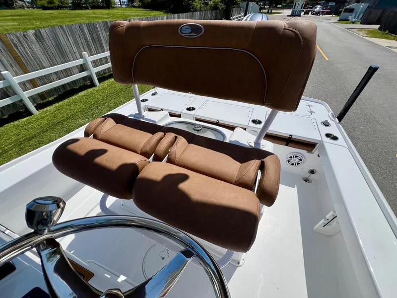 Slide: The Image of 2025 Sea Hunt BX22BR boat with brown cushioned seating and steering wheel. - 10