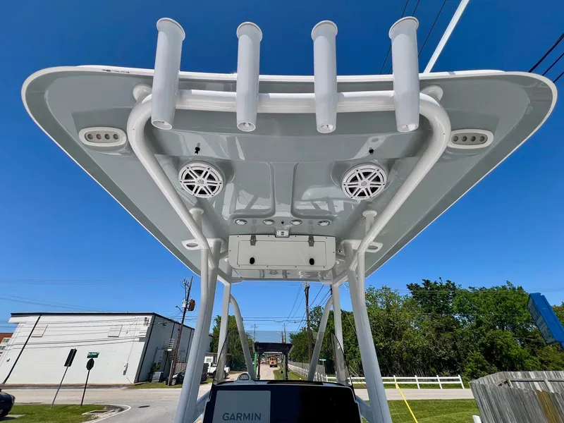Slide: The Image of 2025 Sea Hunt BX22BR boat with T-top, rod holders, and speakers under clear blue sky. - 12
