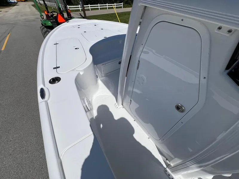 Slide: The Image of 2025 Sea Hunt BX22BR boat deck, white finish, spacious layout, parked on a road. - 13