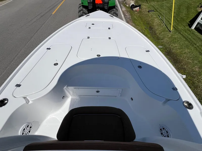 Slide: The Image of 2025 Sea Hunt BX22BR boat deck with storage compartments, parked on roadside. - 15