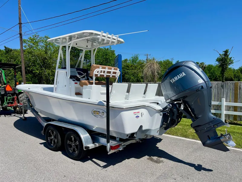 Slide: The Image of 2025 Sea Hunt BX22BR boat with Yamaha engine on trailer, parked outdoors. - 2