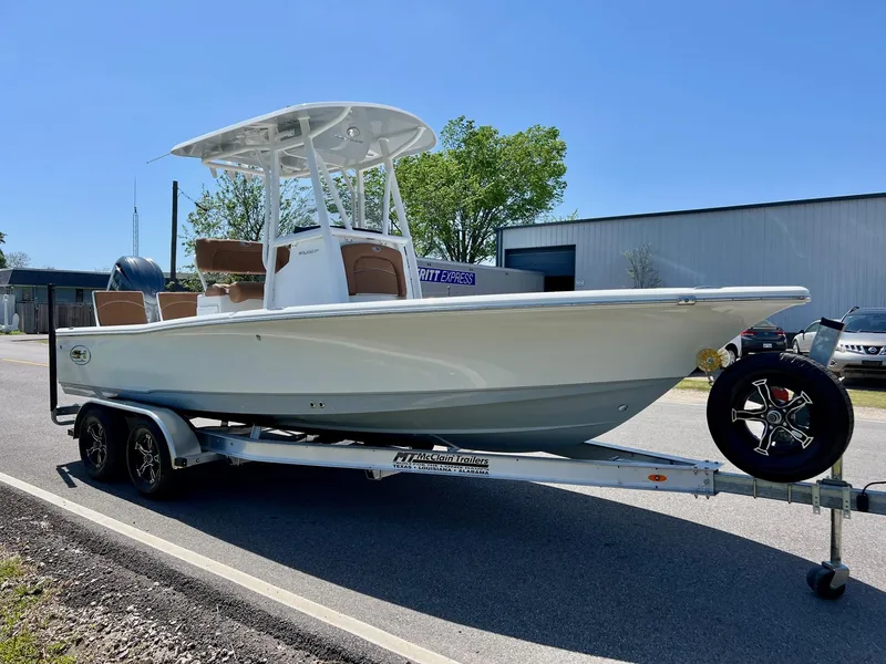 Slide: The Image of 2025 Sea Hunt BX22BR boat on trailer, parked outdoors under clear blue sky. - 5