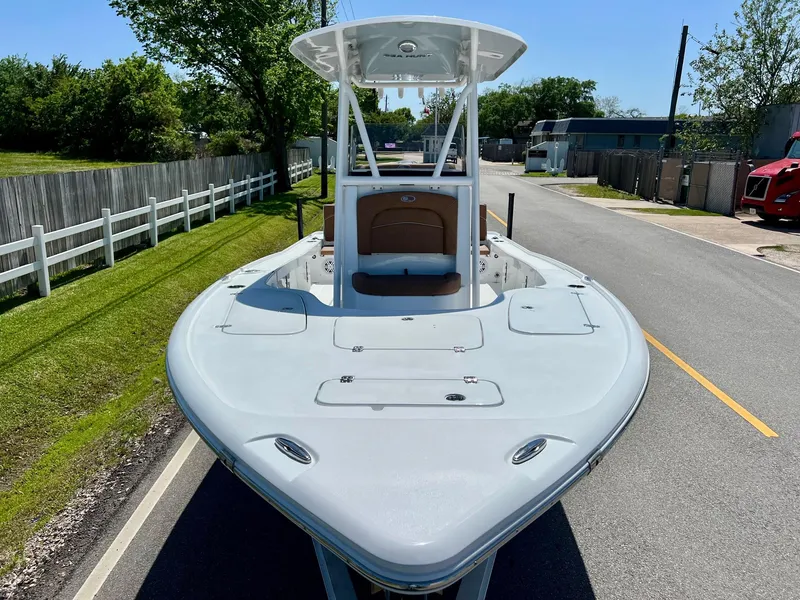 Slide: The Image of 2025 Sea Hunt BX22BR boat on a road, showcasing sleek design and spacious deck. - 6