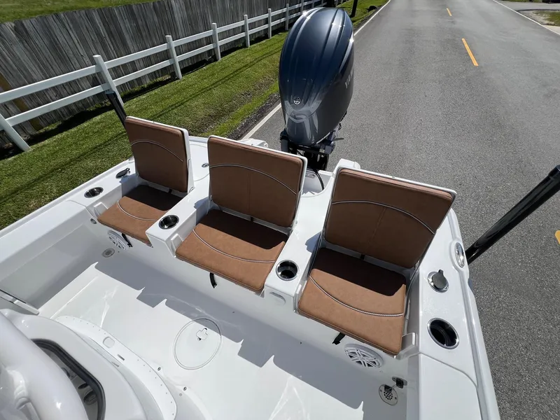Slide: The Image of 2025 Sea Hunt BX22BR boat with three brown seats and an outboard motor on a road. - 7