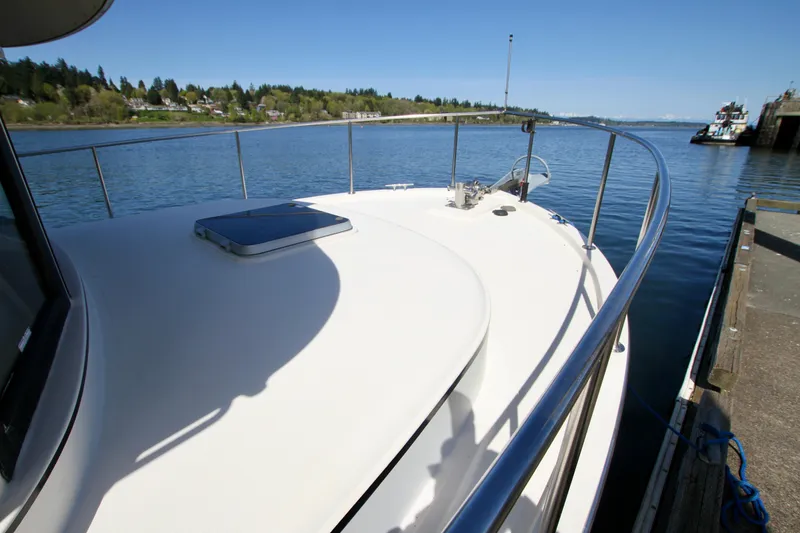 Slide: The Image of 1995 Camano Troll boat docked by a calm waterfront, clear sky in the background. - 12
