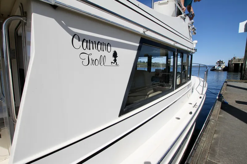 Slide: The Image of 1995 Camano Troll boat docked, showcasing sleek design and logo on the side. - 13