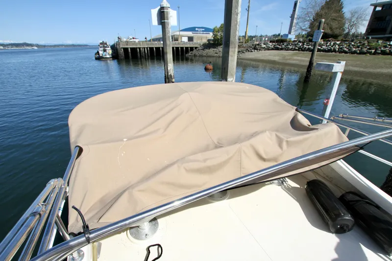Slide: The Image of 1995 Camano Troll boat with covered deck, docked by a calm waterfront. - 14