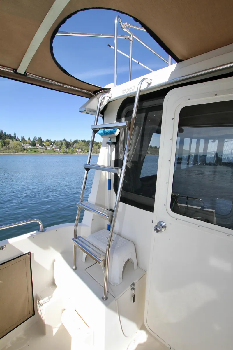 Slide: The Image of 1995 Camano Troll boat with ladder, docked on a serene lake. - 17