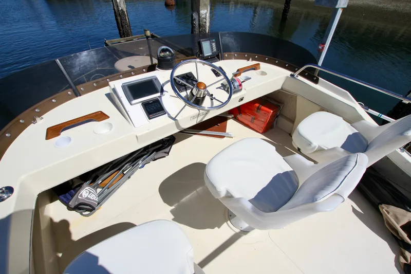 Slide: The Image of 1995 Camano Troll boat cockpit with steering wheel, navigation equipment, and seating. - 21