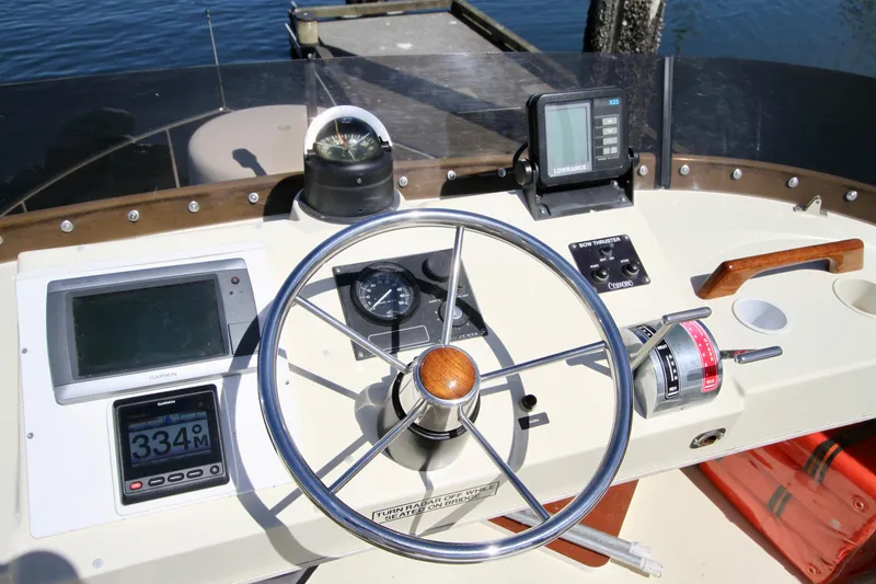 Slide: The Image of 1995 Camano Troll boat helm with steering wheel, navigation instruments, and compass. - 22