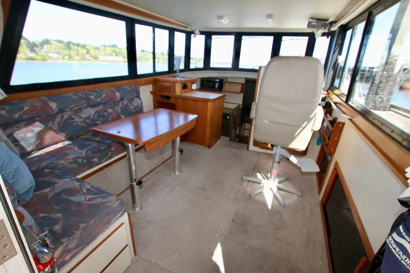 Slide: The Image of Interior of a 1995 Camano Troll boat with seating, table, and helm station. - 24