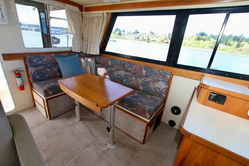Slide: The Image of Interior of a 1995 Camano Troll boat with seating and table, overlooking water. - 25