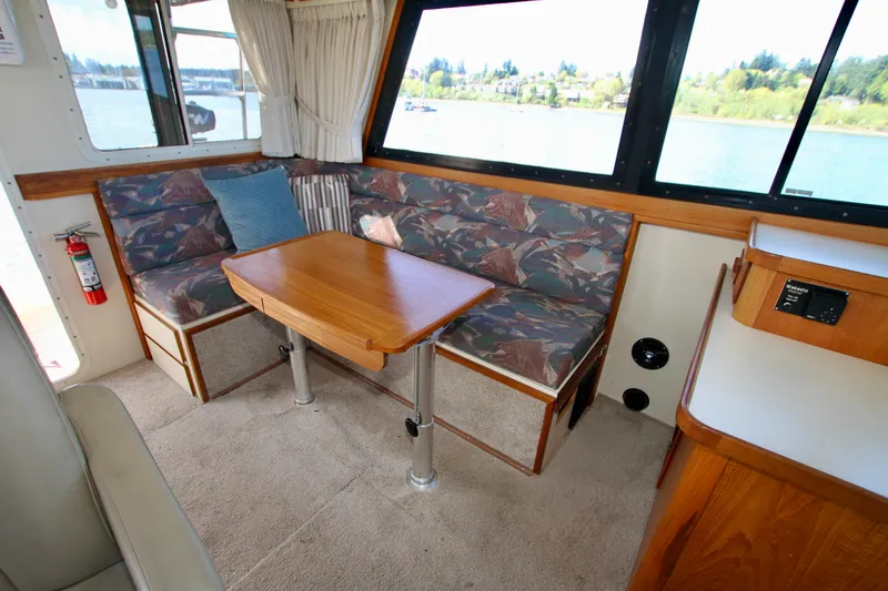Slide: The Image of Interior of 1995 Camano Troll boat with cozy seating and wooden table by large windows. - 26