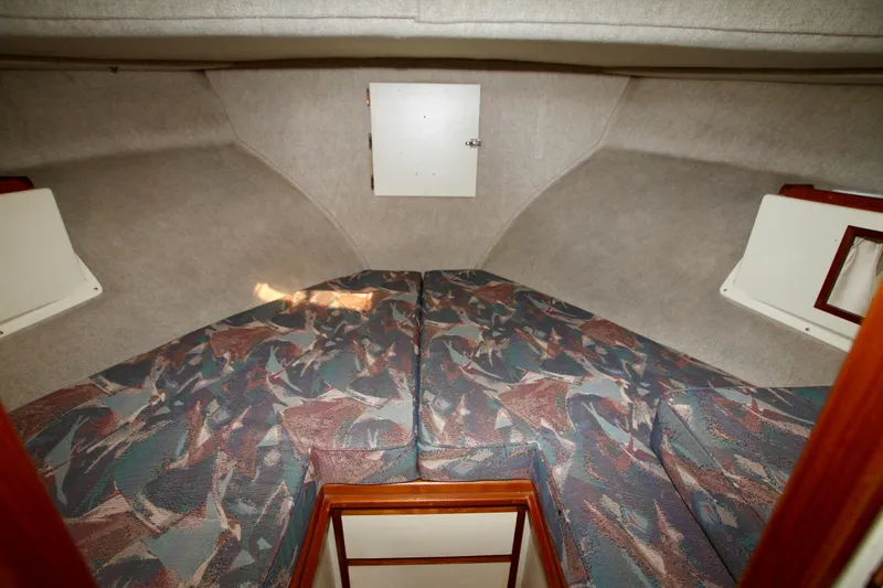 Slide: The Image of 1995 Camano Troll boat interior with patterned bedding and storage compartments. - 35