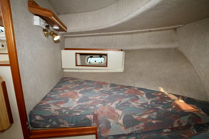 Slide: The Image of 1995 Camano Troll boat cabin with patterned bedding and small window. - 37