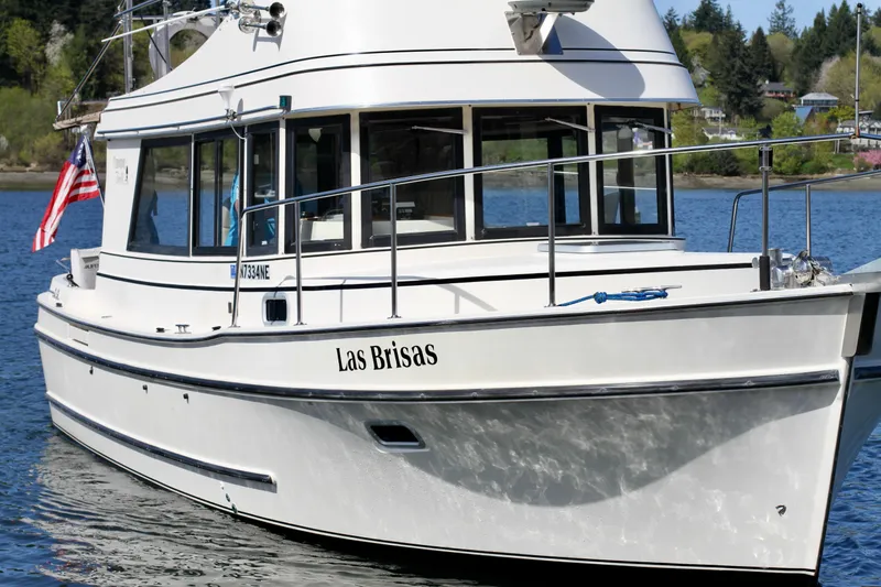 Slide: The Image of 1995 Camano Troll boat named "Las Brisas" on a serene lake with American flag. - 4