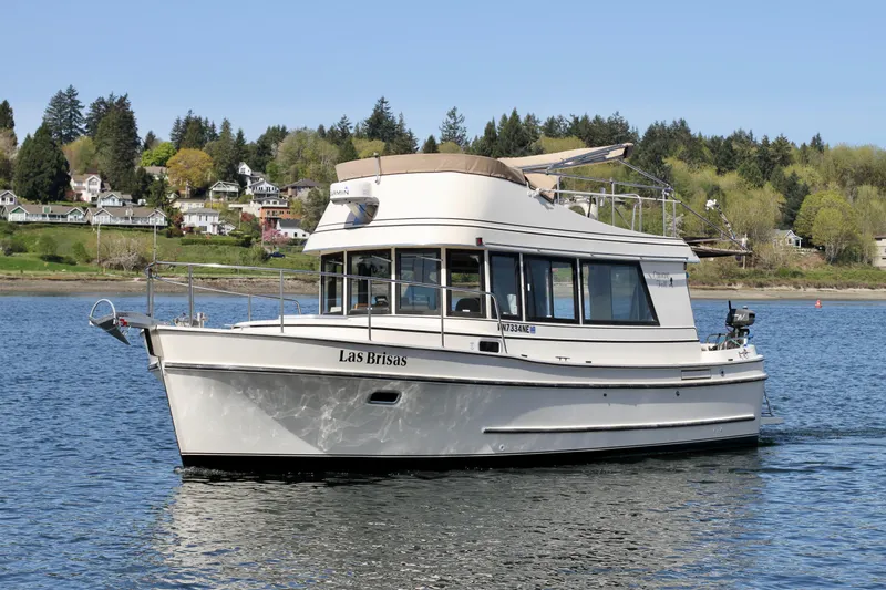 Slide: The Image of 1995 Camano Troll boat on a serene lake with lush green shoreline. - 6