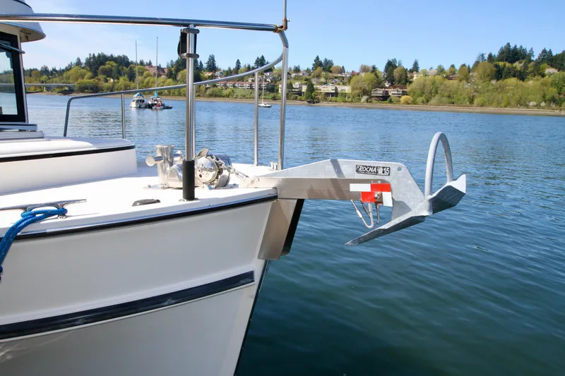 Slide: The Image of 1995 Camano Troll boat with anchor on calm water, scenic background. - 8